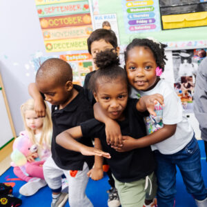 Virginia Preschool Initiative (VPI) Smiling children hugging each other.